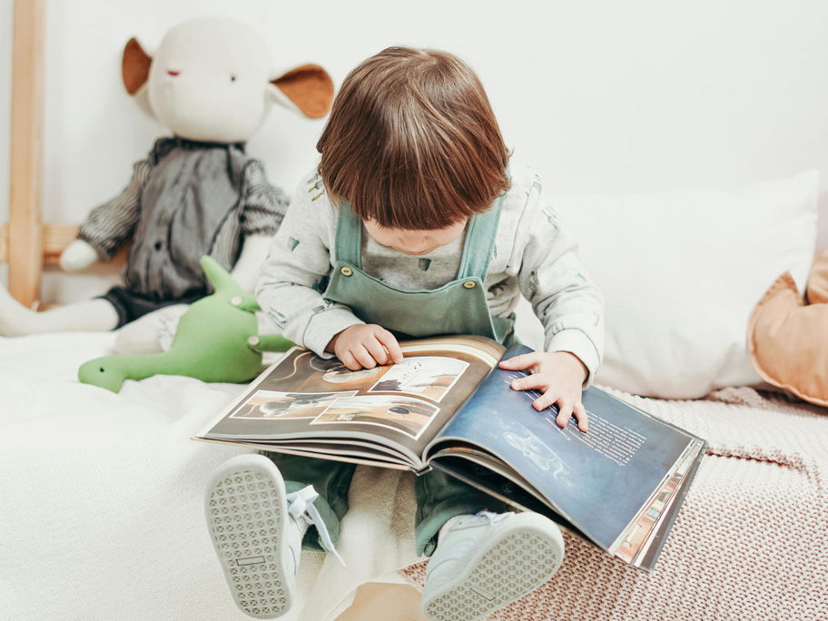 Ein Kleinkind liest ein Buch.