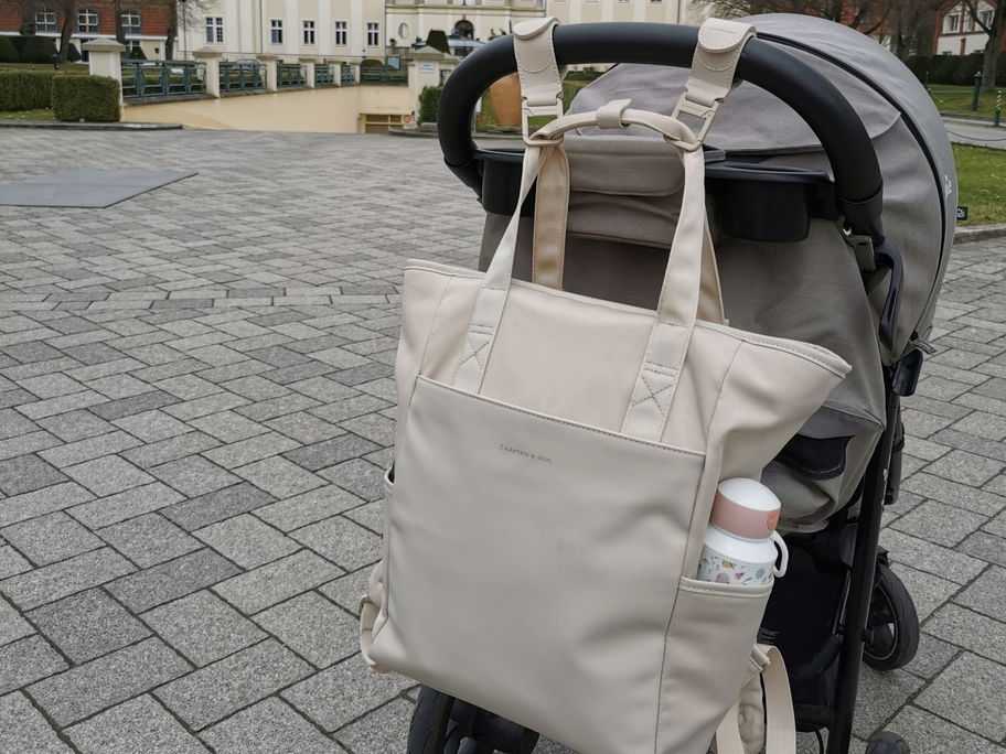 Der Wickelrucksack in Sandstone von Kapten & Son hängt am Buggy unserer Redakteurin.
