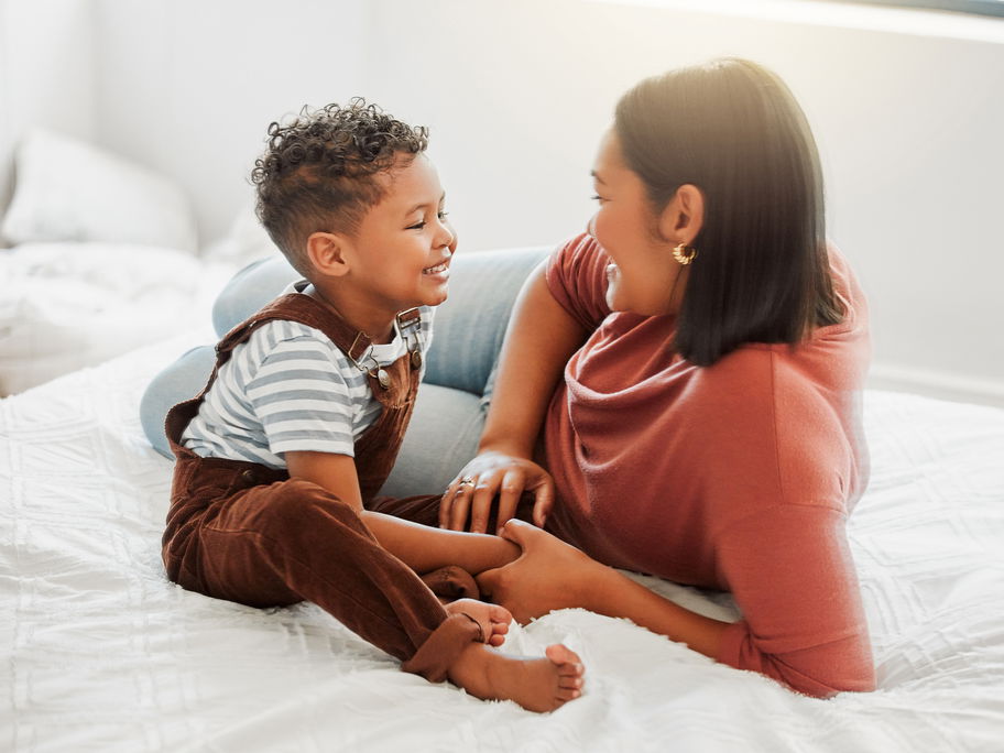 Mutter und Sohn liegen auf dem Bett und unterhalten sich.
