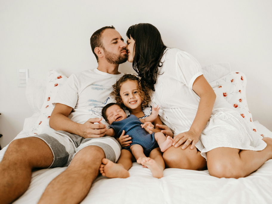 Vierköpfige Familie zusammen im Bett.