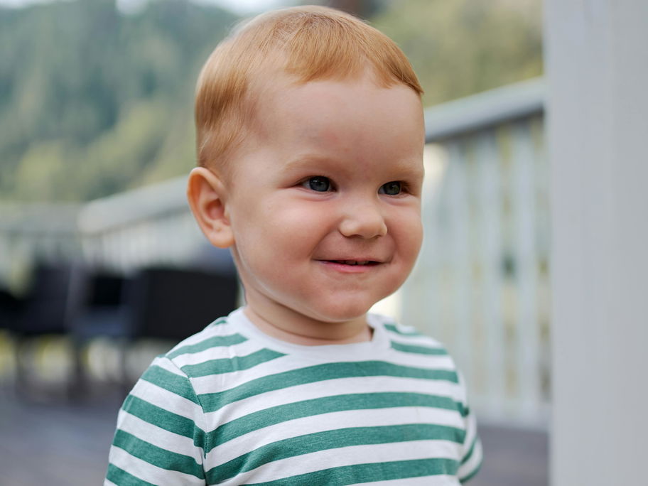 Ein kleiner Junge schaut verschmitzt.