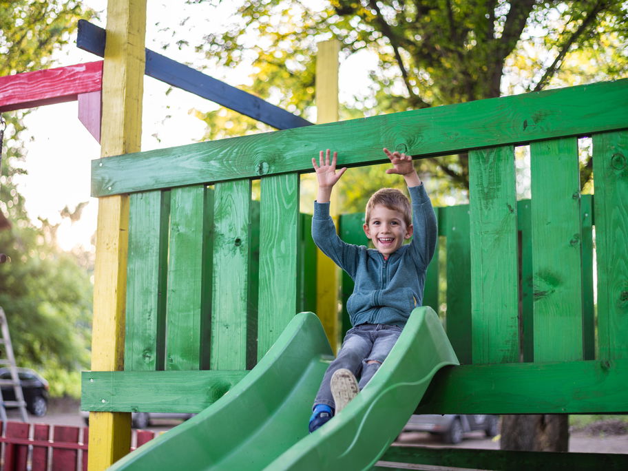 Eine Junge auf einem Klettergerüst am Spielplatz.