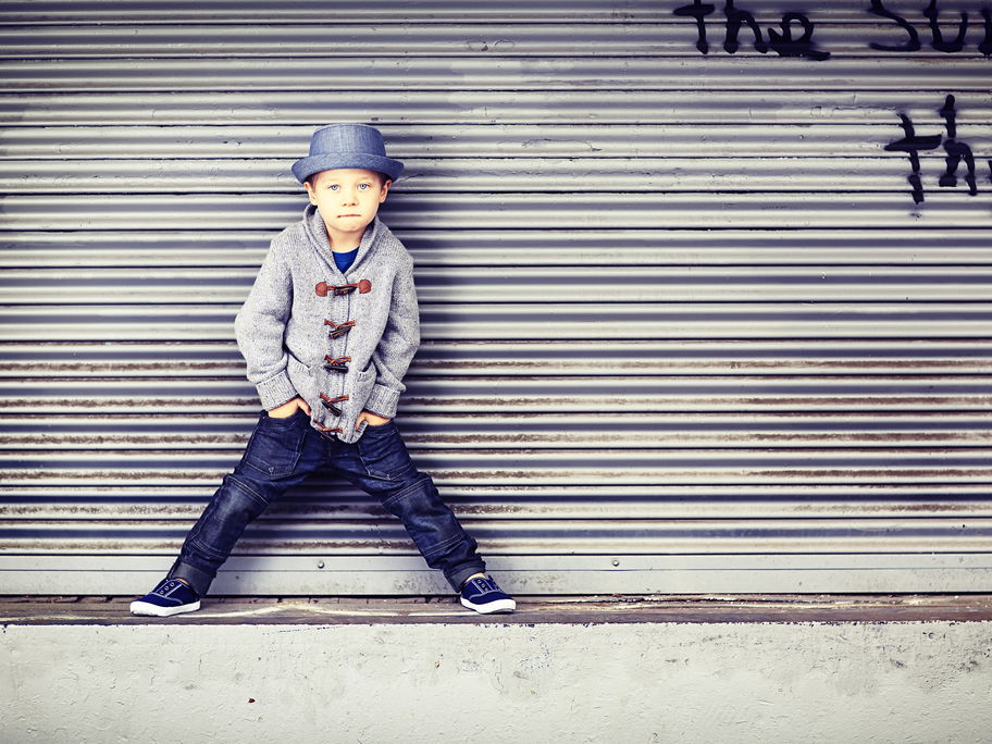 Kleiner Junge in mit Hut posiert cool.