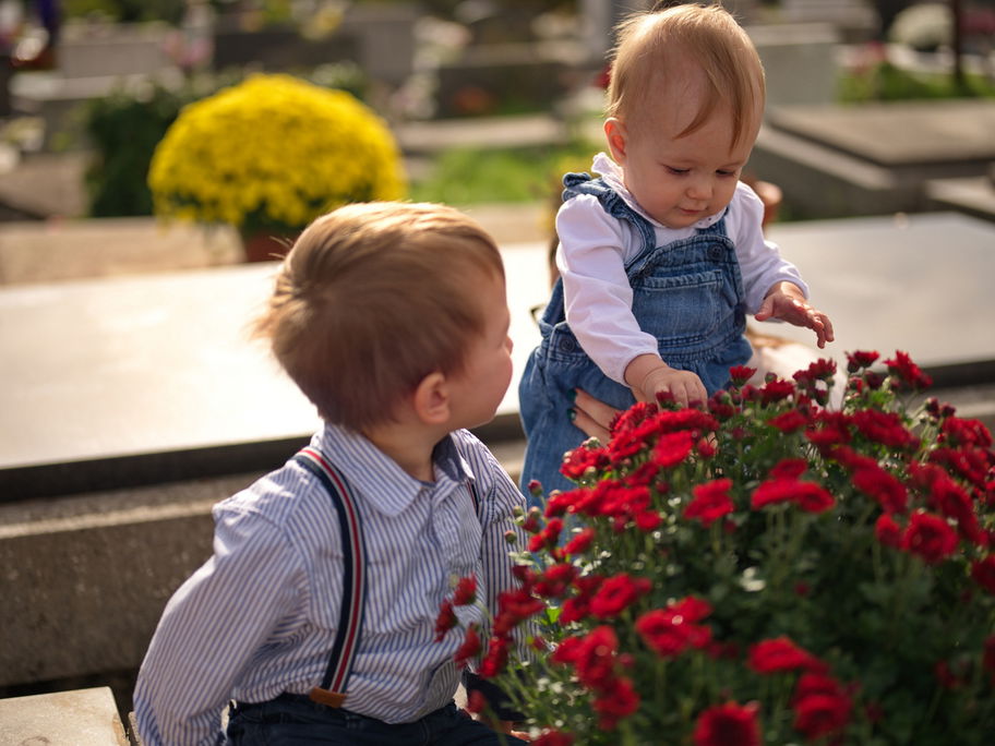 Zwei kleine Kinder auf einem Friedhof.