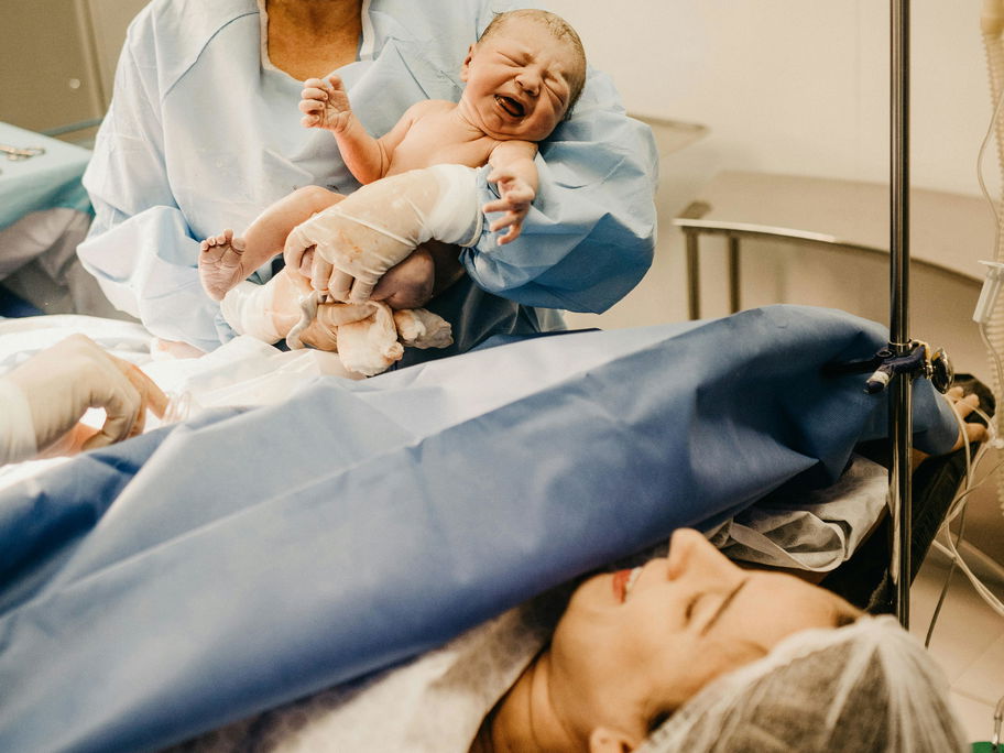 Eine Frau im Kreißsaal hat gerade ihr Baby bekommen