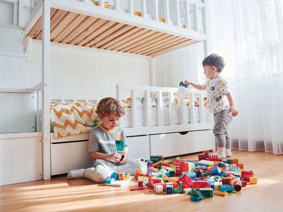 Zwei Jungs spielen neben ihrem Hochbett.