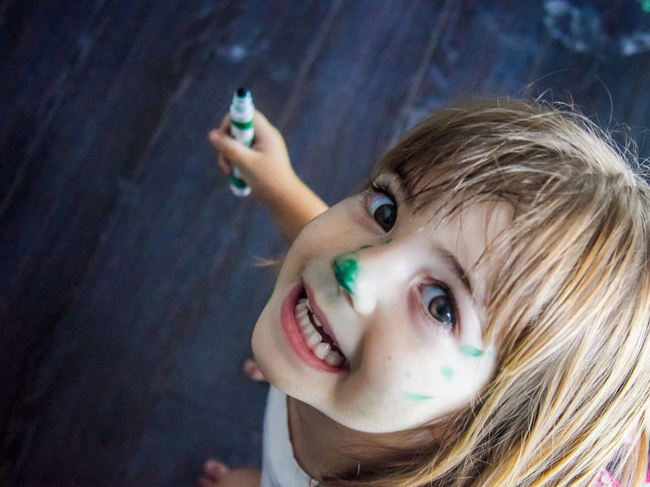 Lachendes Mädchen mit Stift in der Hand.