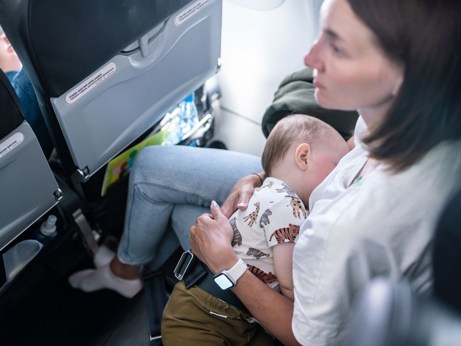 Mutter mit Baby im Flugzeug.