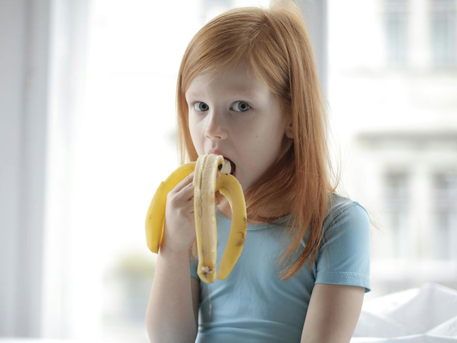 Kind isst Banane.