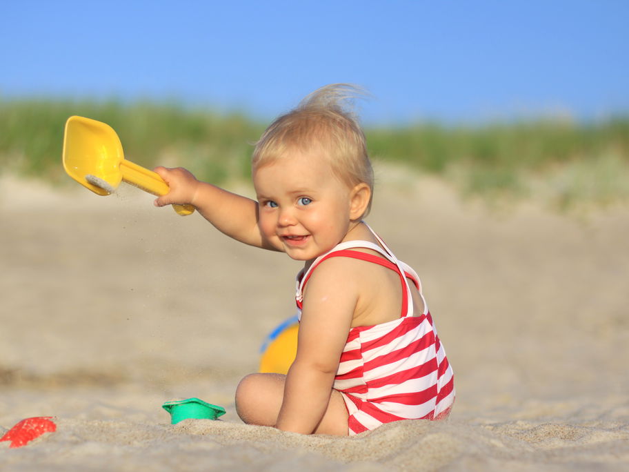 Ein Baby, das am Strand buddelt.