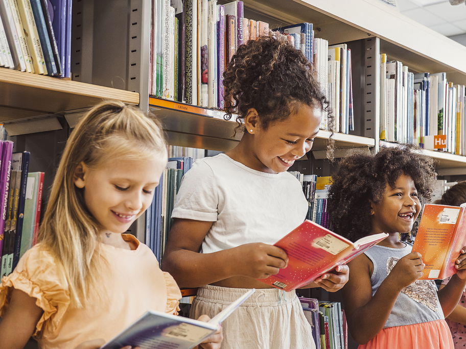 Kinder lesen in der Bibliothek.