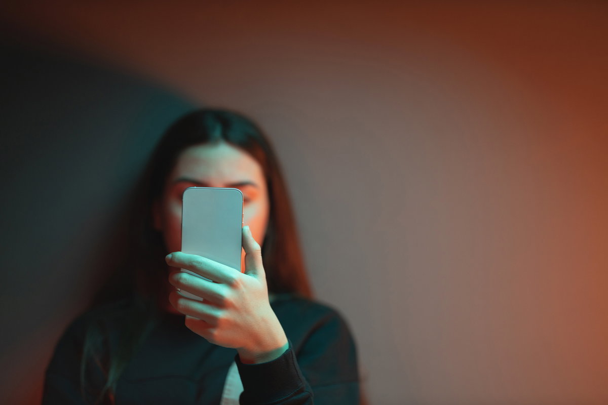 Schülerin liest Nachricht auf ihrem Handy