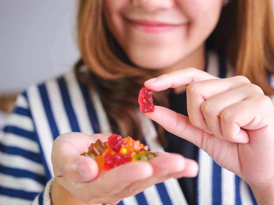 Eine Frau hält Gummibärchen in der Hand