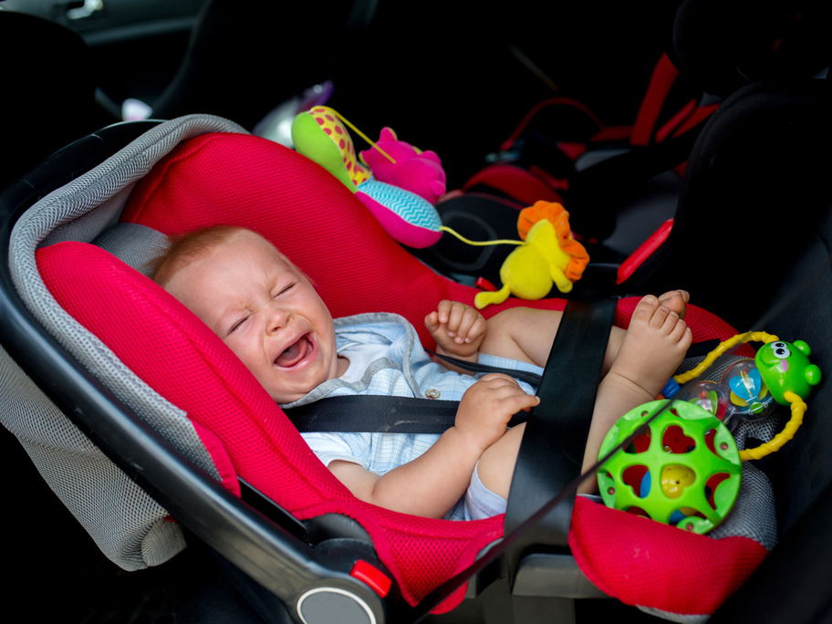 Baby schreit im Kindersitz.
