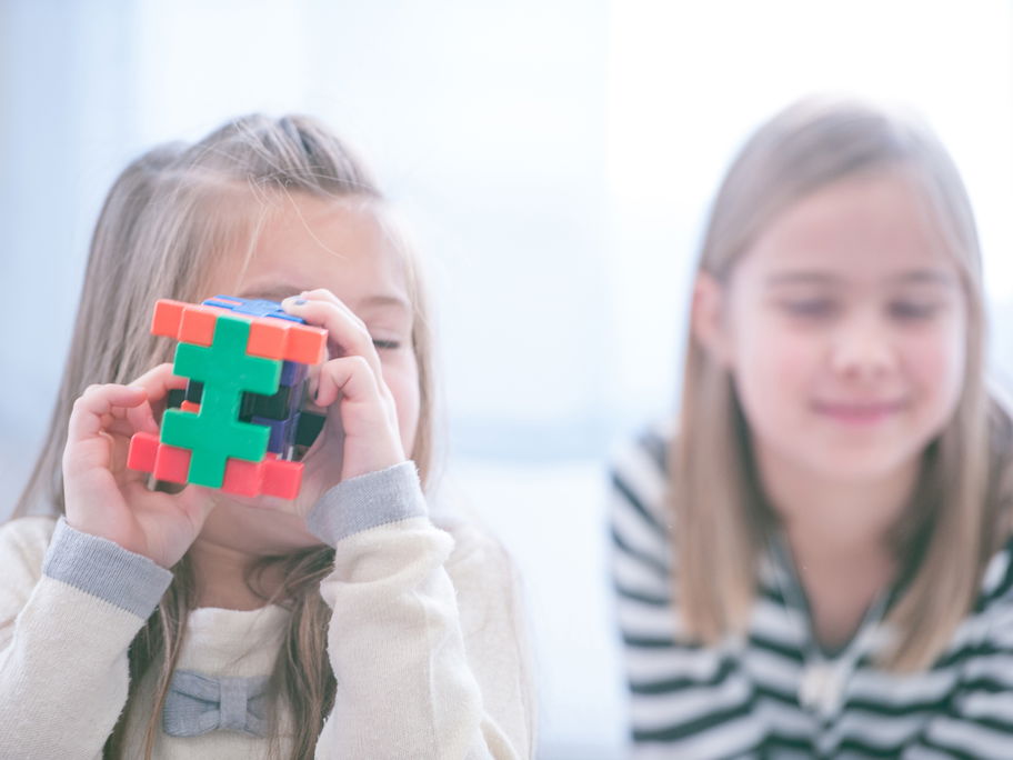 Zwei Mädchen, eins mit Spielzeug.