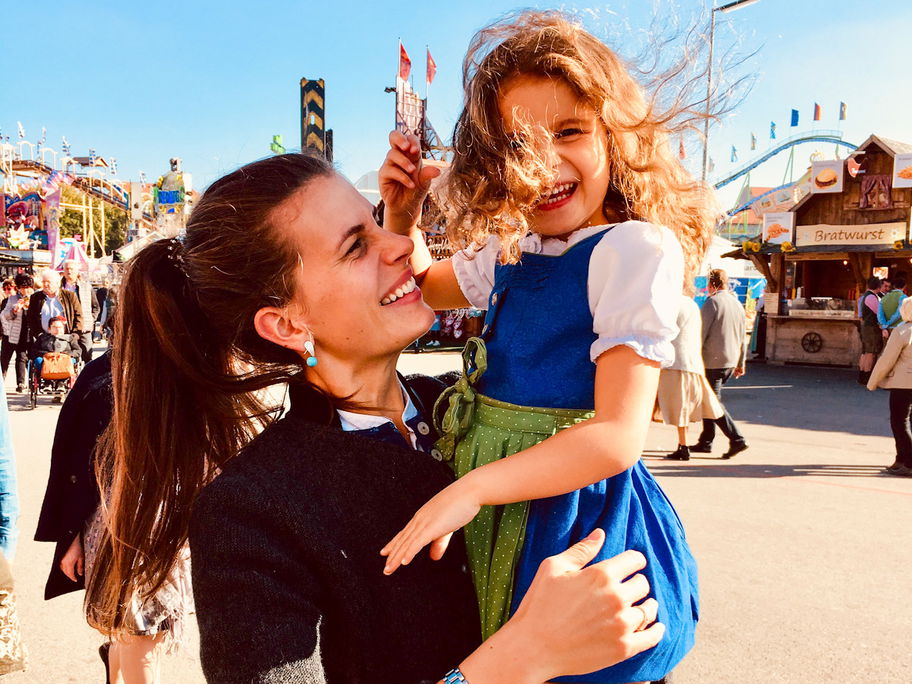Eine Frau im Dirndl auf dem Oktoberfest mit ihrer Tochter.
