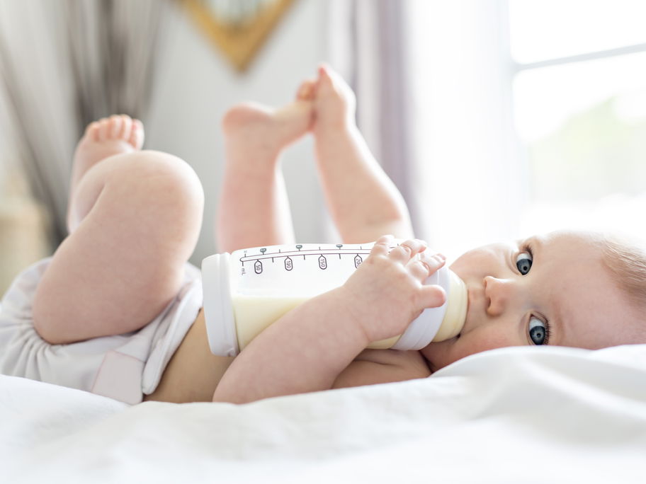 Baby trinkt aus Fläschchen.