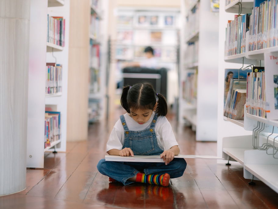 Mädchen liest in Kinderbuchhandlung.