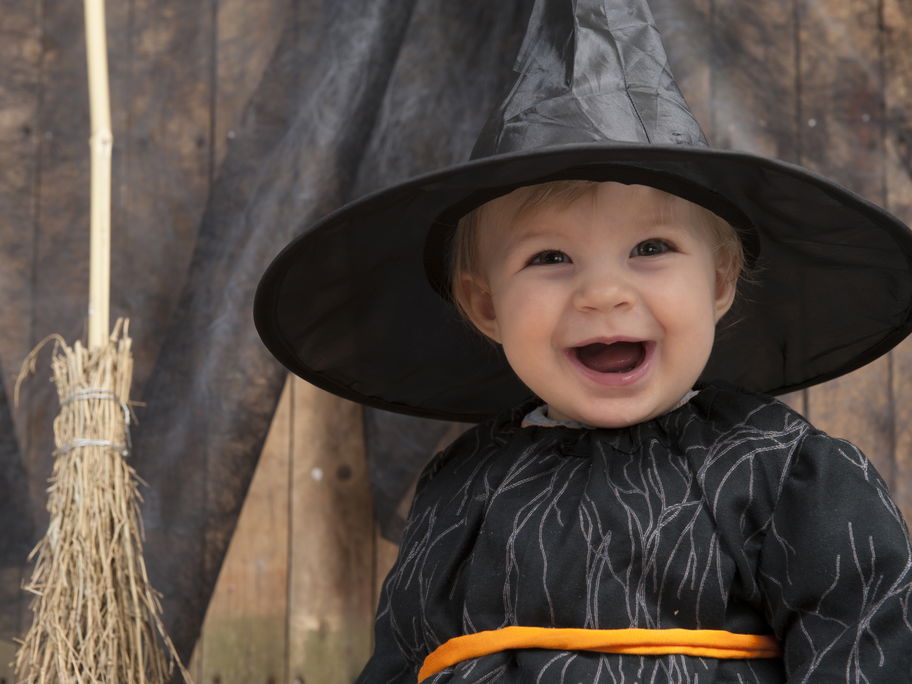 Kleinkind an Halloween mit Hexenkostüm.