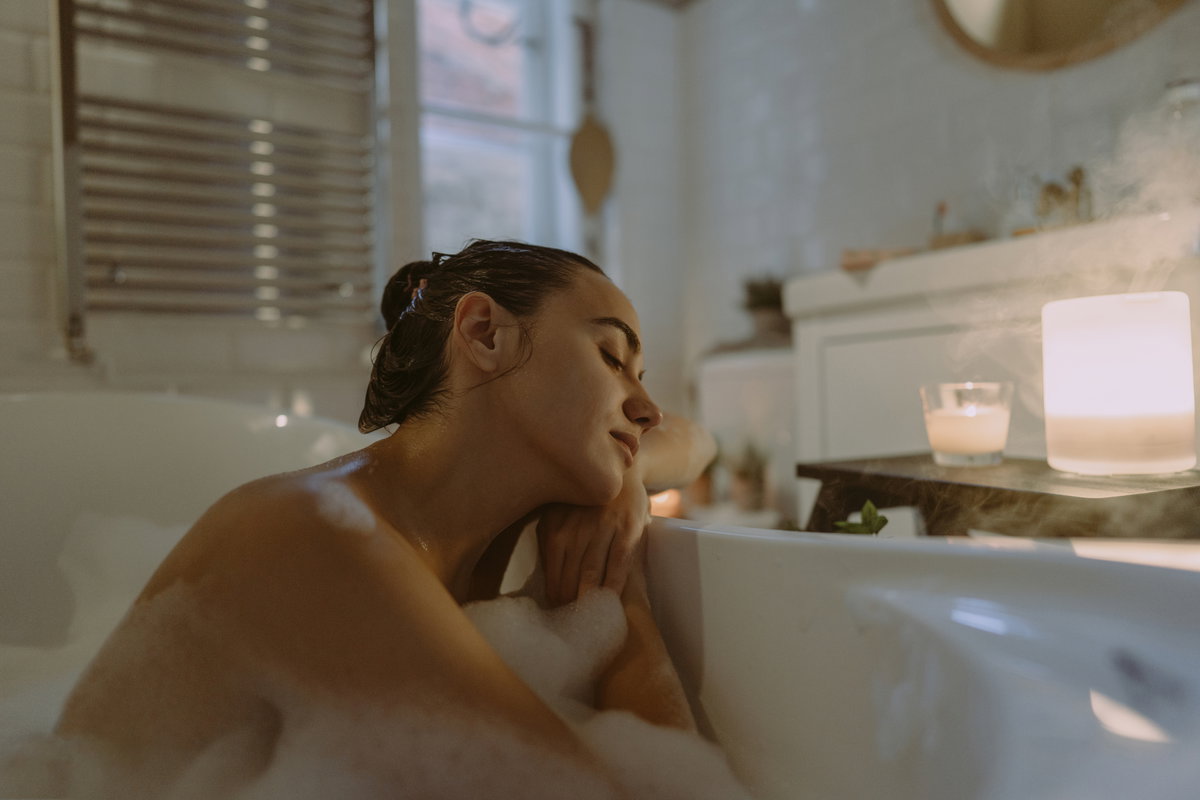 Eine Frau, die in der Badewanne sitzt und die Augen schließt.