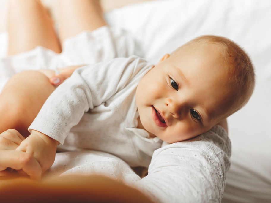 Baby liegt im Arm der Mutter.