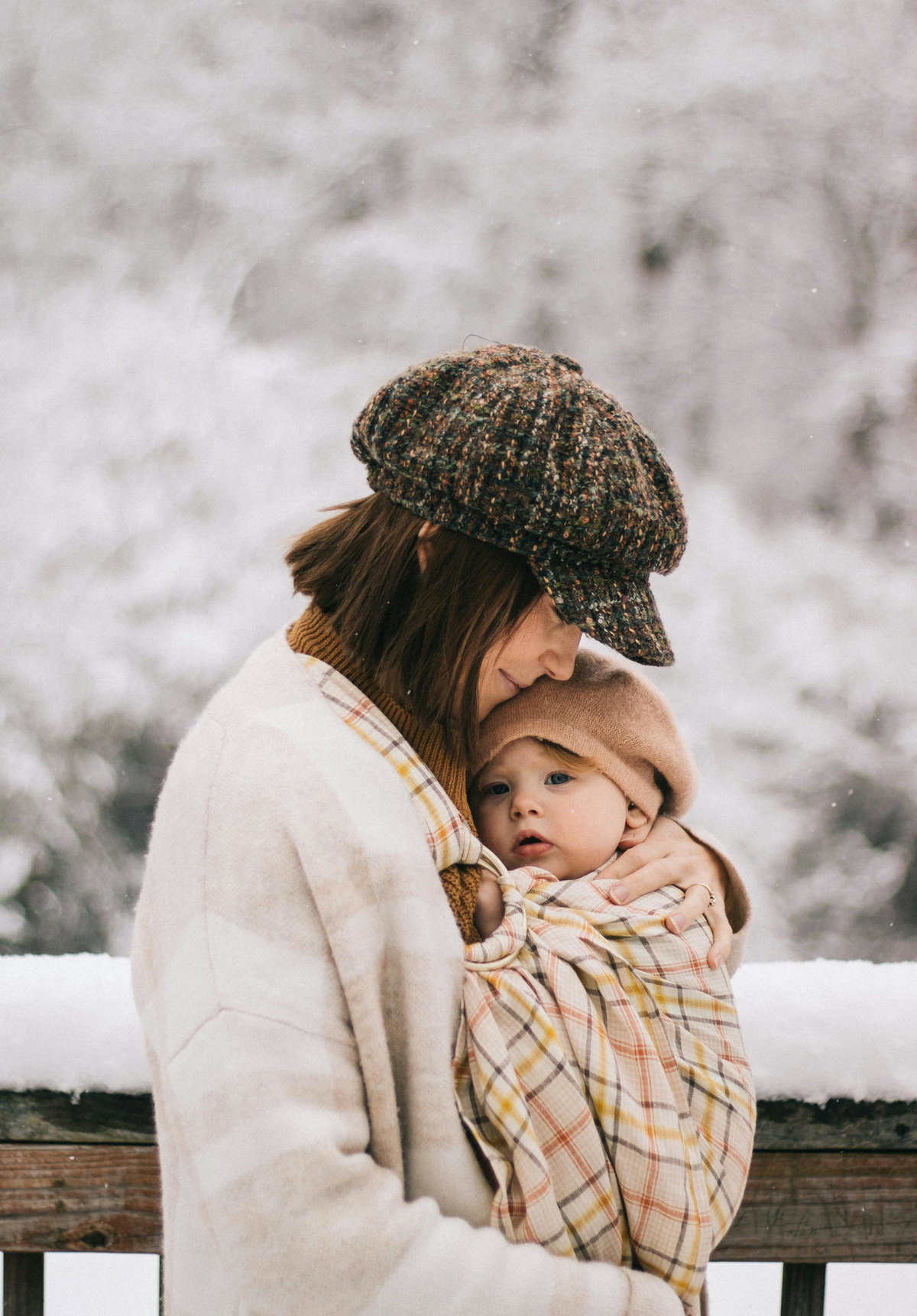 Mama kuschelt im Winter mit Baby