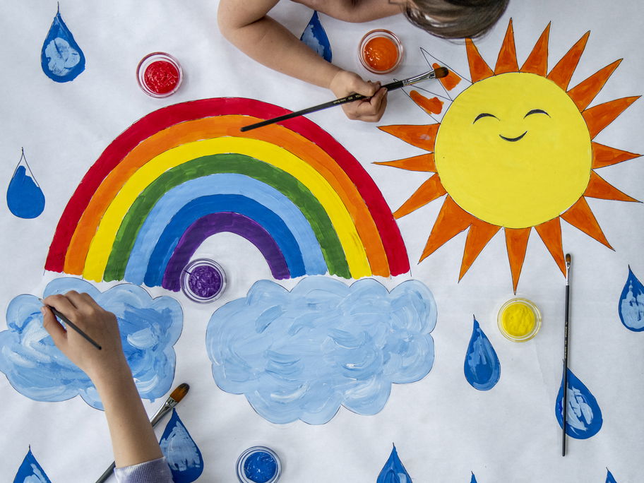 Kinder malen Regenbogen.