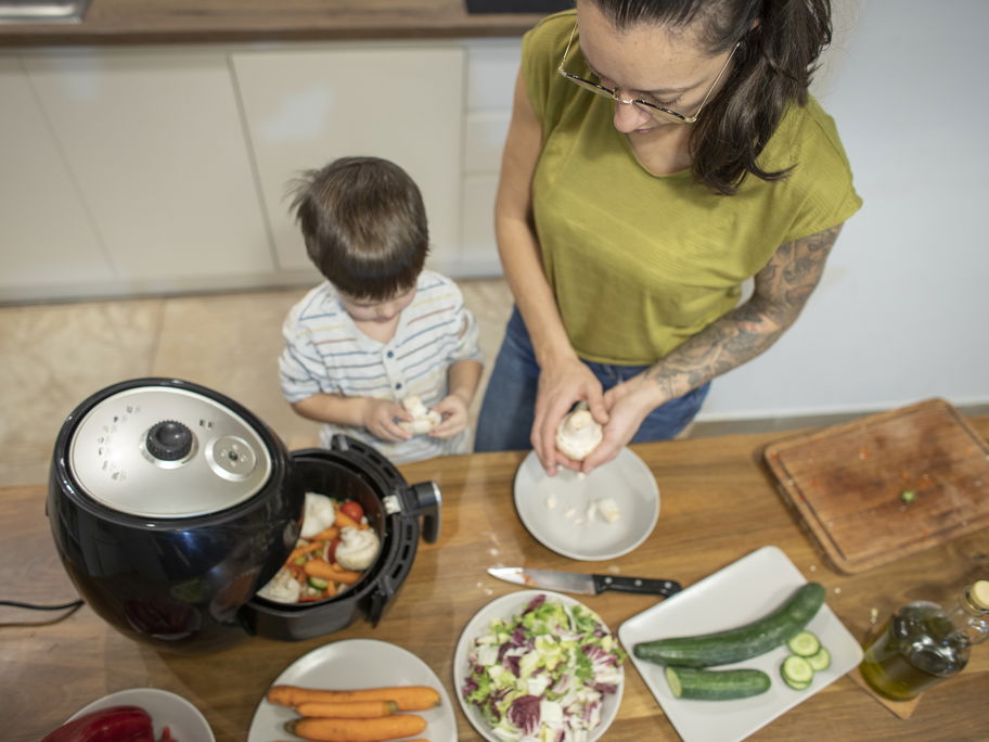 Mutter und Kind kochen mit dem Airfryer.