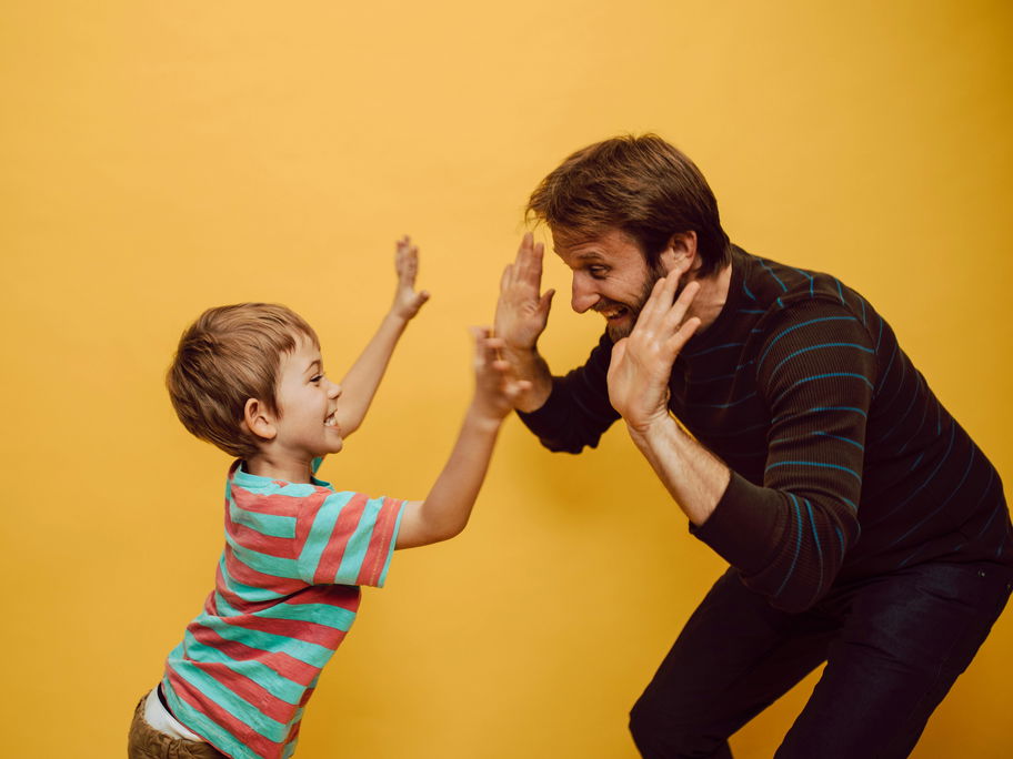 Ein Papa und Sohn klatschen ab.