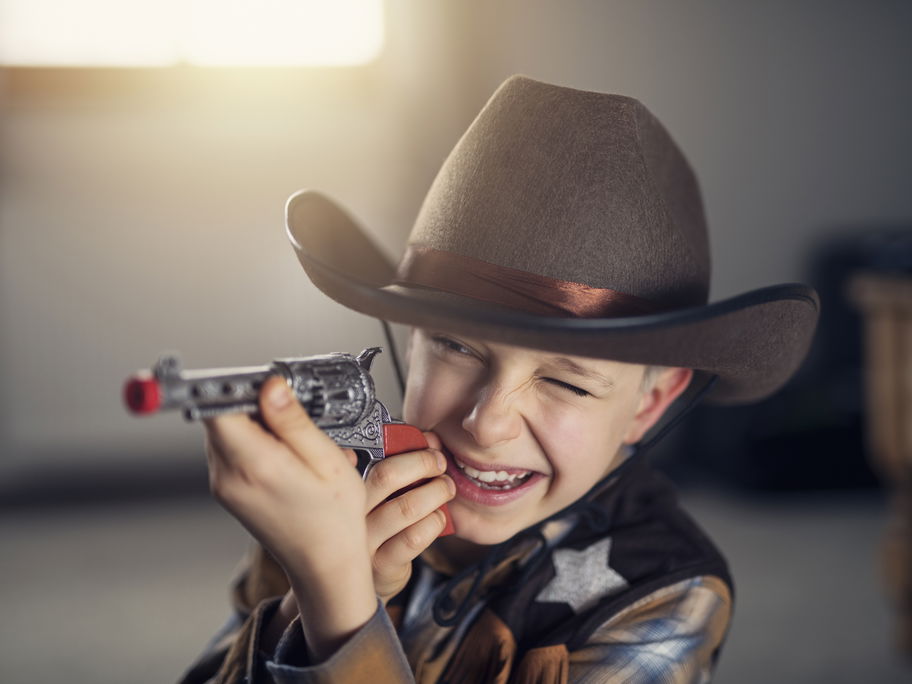 Ein Junge als Cowboy mit Spielzeugpistole