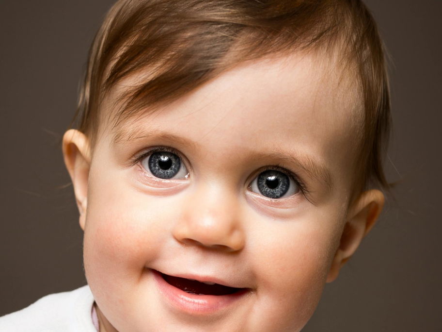 Ein süßer Baby-Junge lächelt in die Kamera.