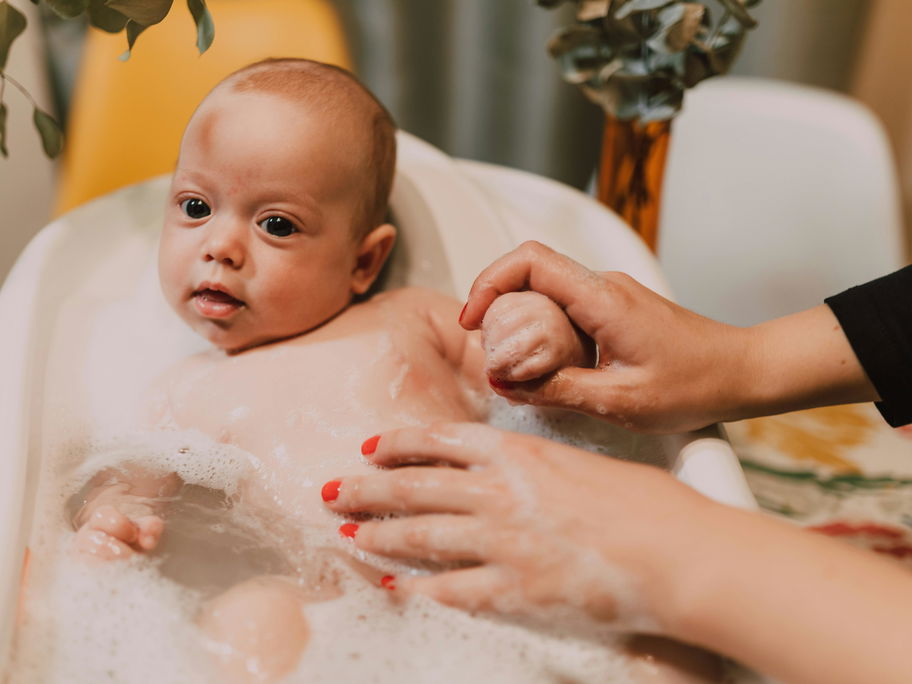 Mutter badet ihr Baby