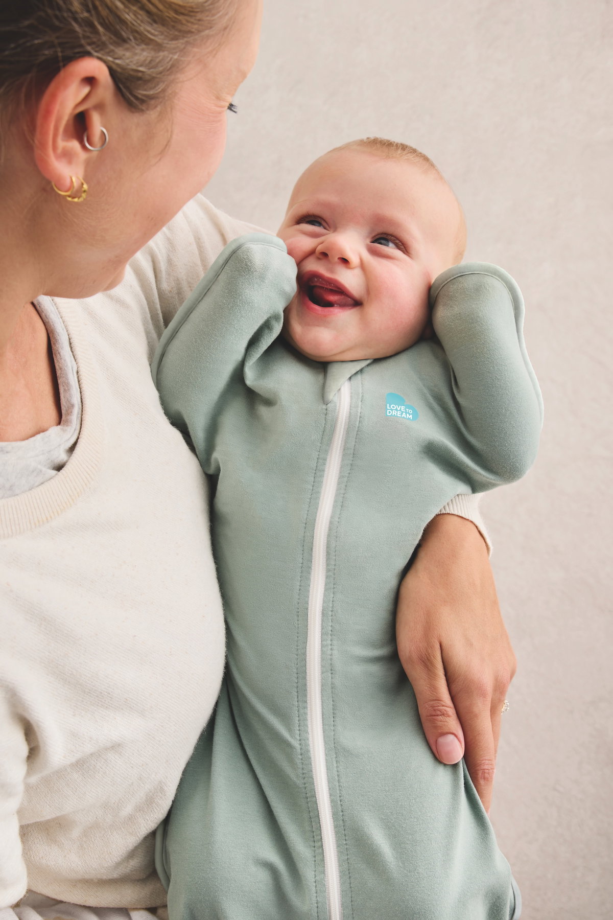 Baby im Pucksack auf Mamas Arm.