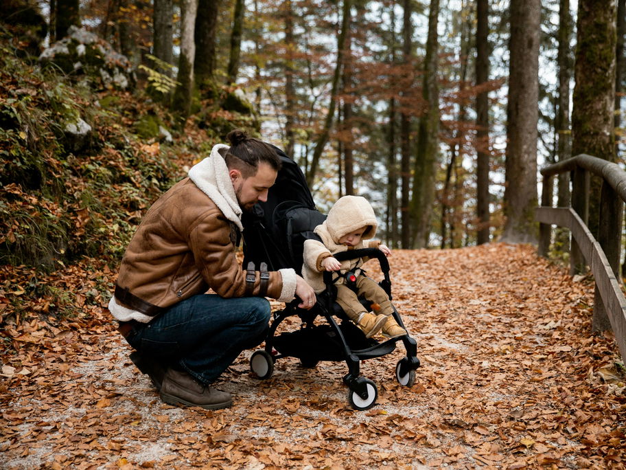 Vater mit Kind im Herbstwald.