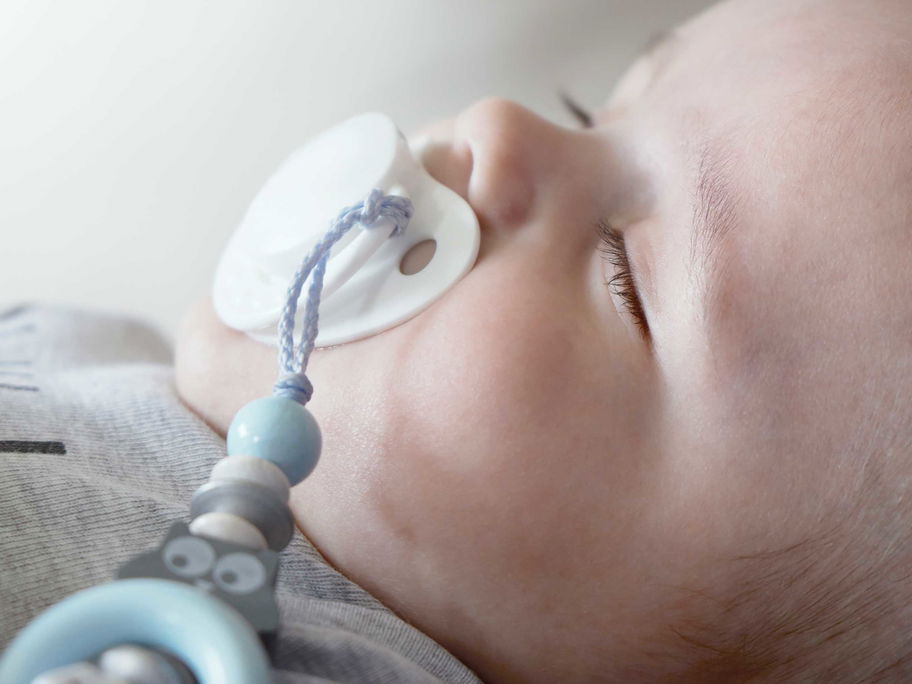 Keine Nuckel-Suche mehr! Eine Schnullerkette kann – praktisch – am Body des Babys befestigt werden.