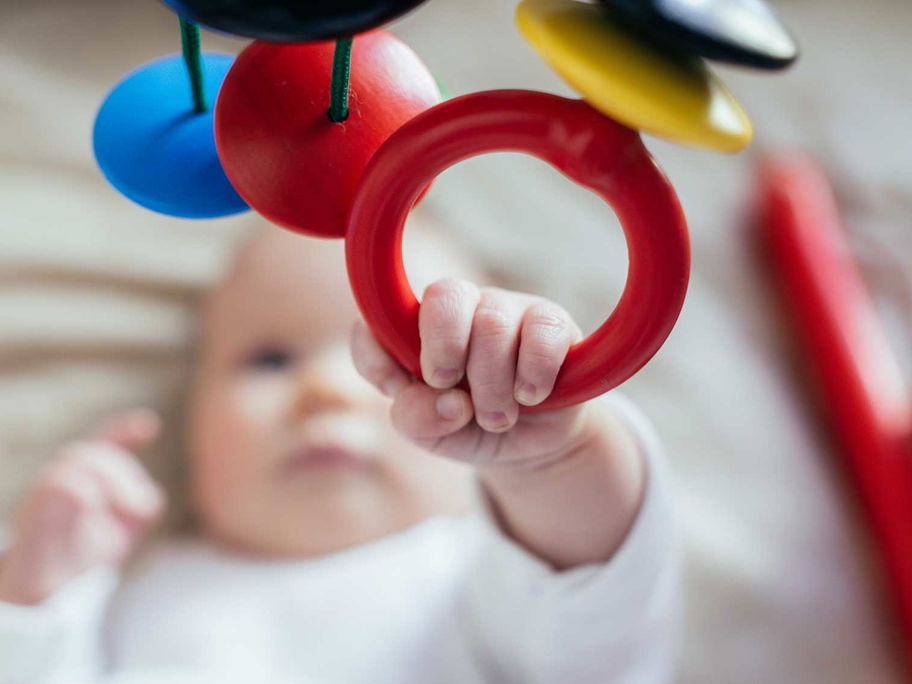 Baby greift nach einem Mobile.