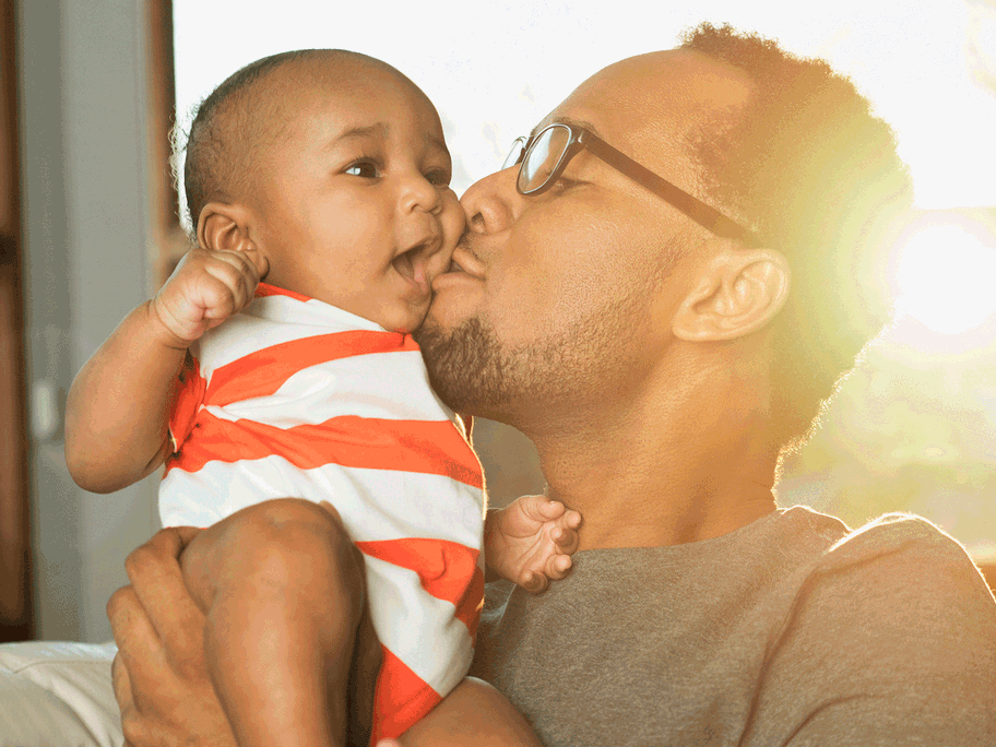Ein Vater küsst sein Baby.