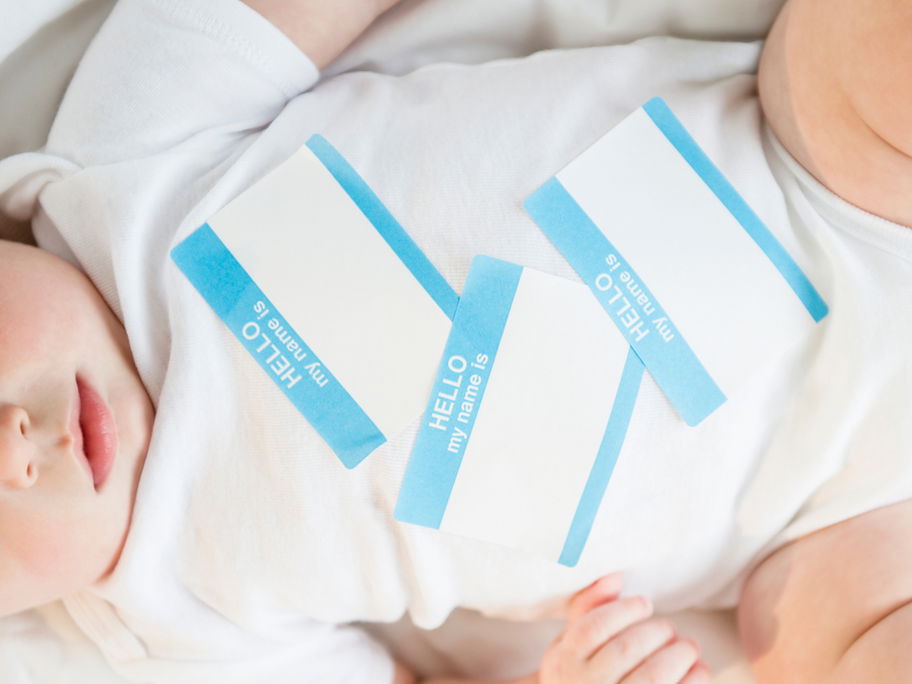Baby im Wickelbody mit Namensaufklebern