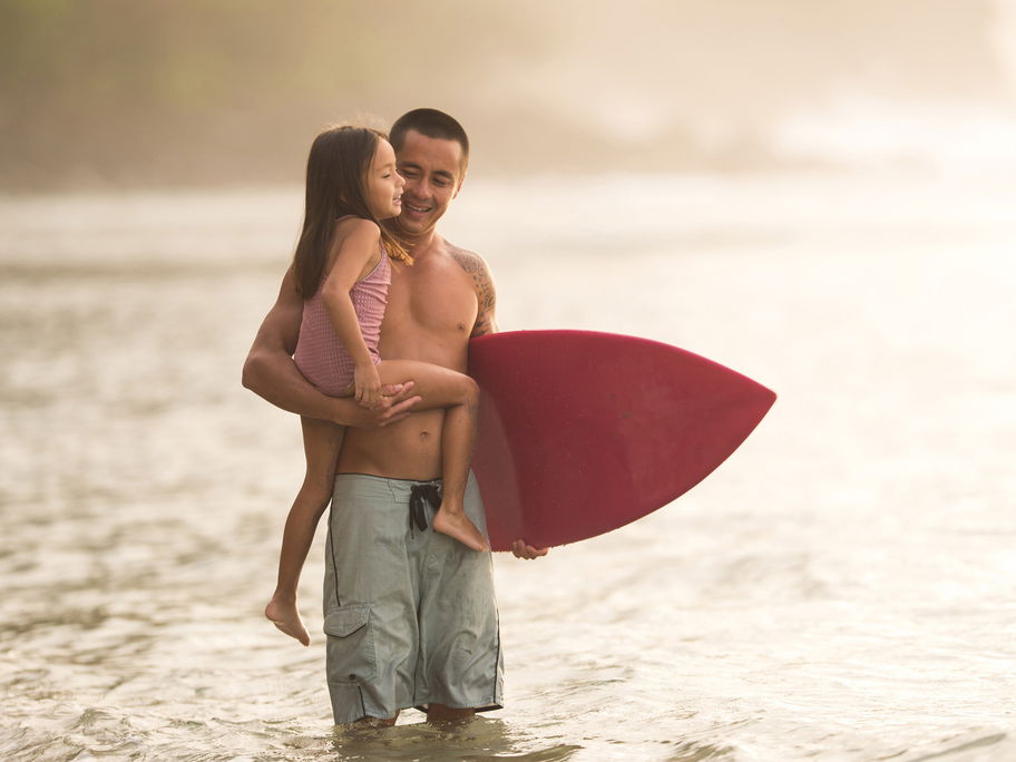 Ein Hawaiianer geht mit seiner Tochter surfen.