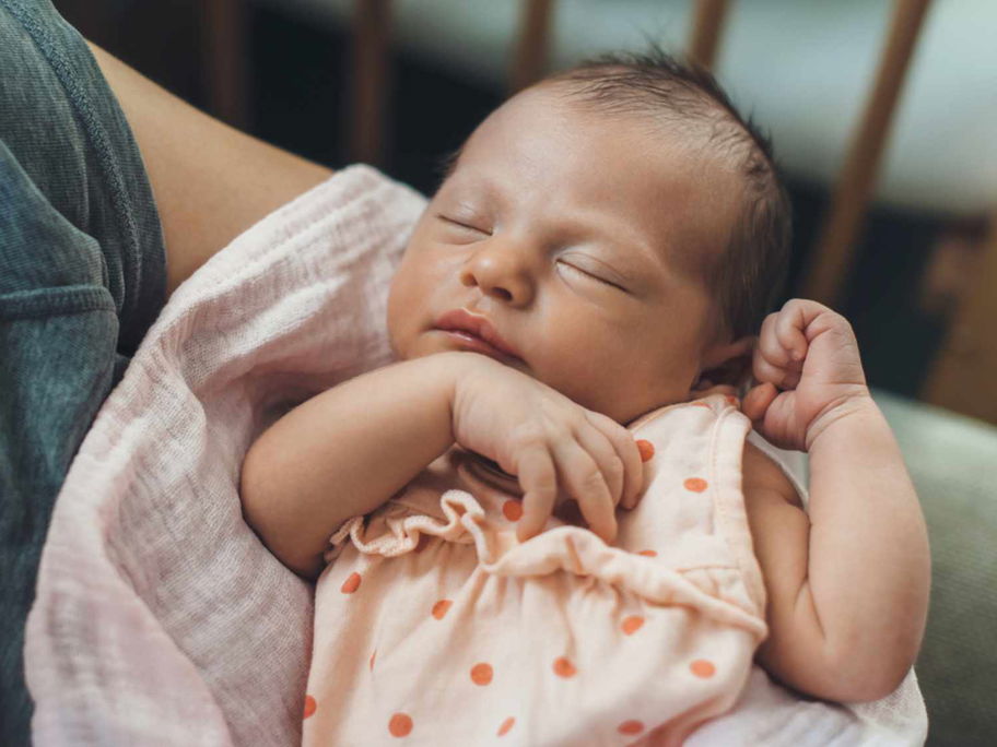 Mutter hält kleines Baby auf dem Arm.