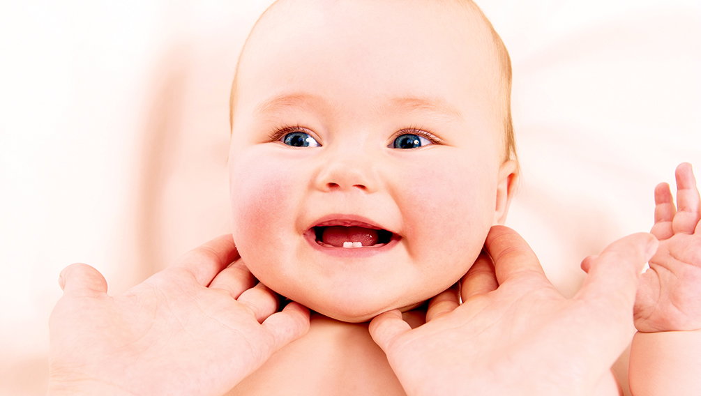 Ein Baby wird am Hals und Nacken massiert.