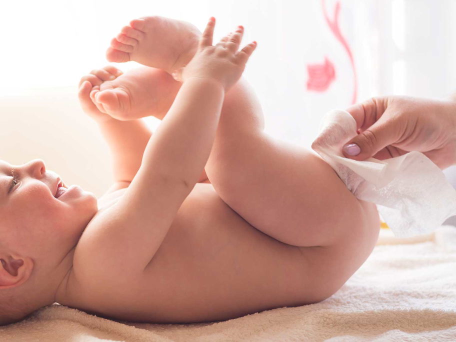 Baby wird beim Wickeln mit dem Feuchttuch abgewischt.