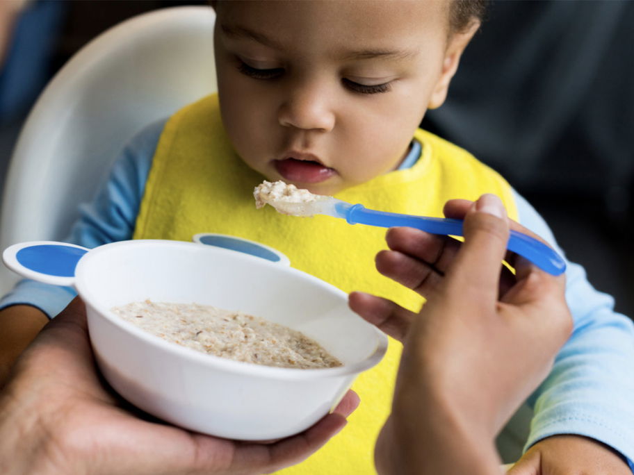 Baby wird mit Getreidebrei gefüttert.
