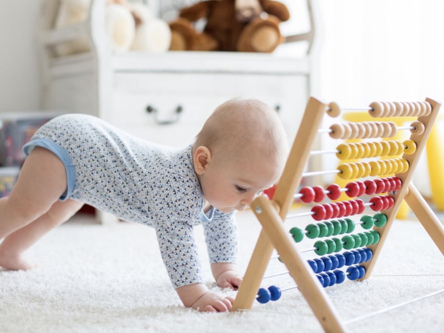 Ein kleines Baby spielt mit einem Rechenschieber.