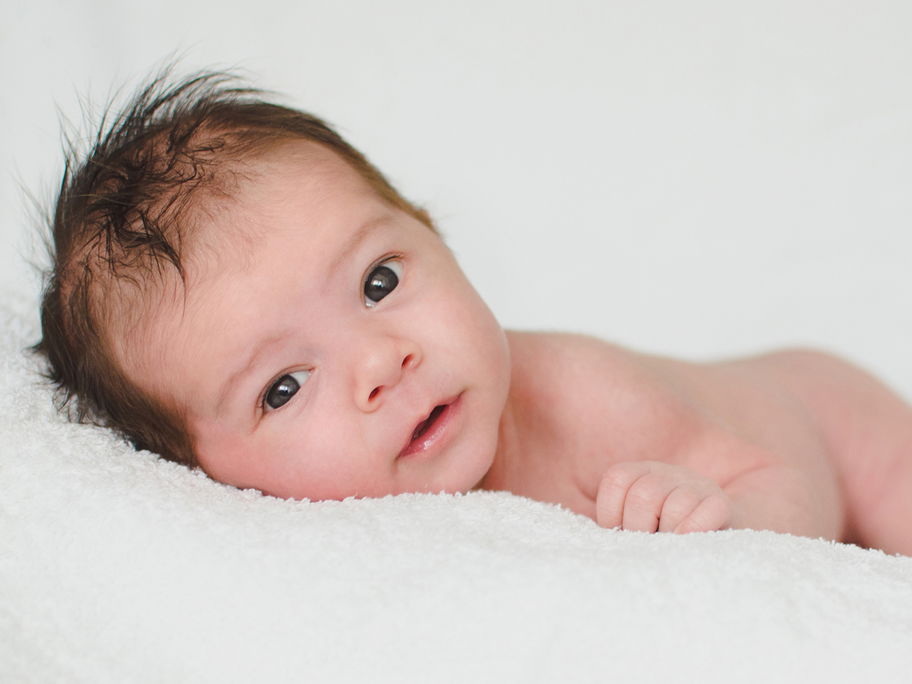 Zwei Monate altes Baby auf einer Decke