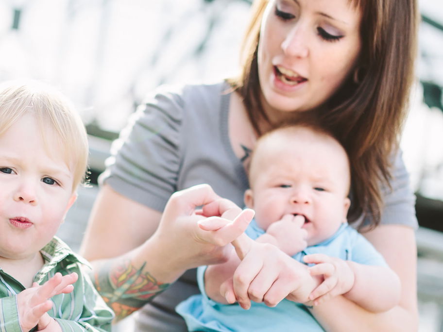 Mutter übt mit Baby und Kleinkind die Babyzeichensprache.