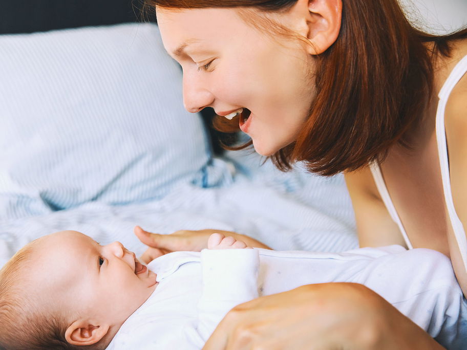 Eine Frau lächelt ihr Baby an.