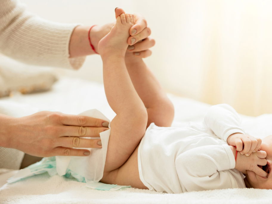 Eine Mutter wechselt ihrem Baby die Windel.