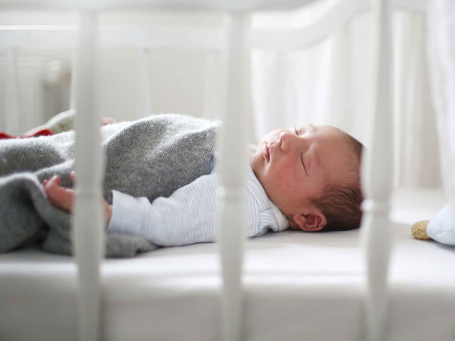 Baby schläft im Bettchen.