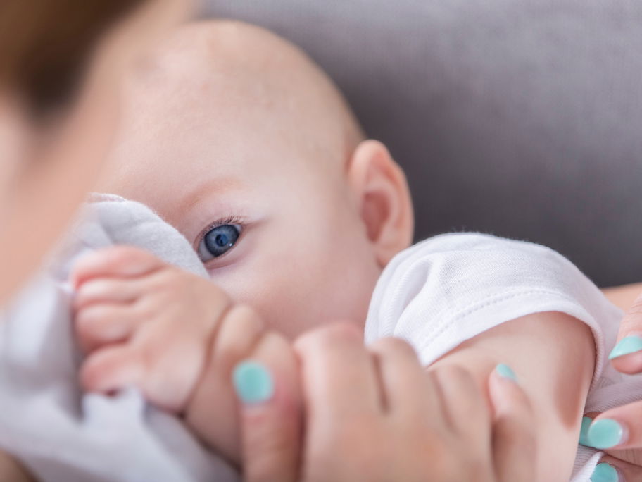 Baby mit Schnuffeltuch auf Mamas Arm.